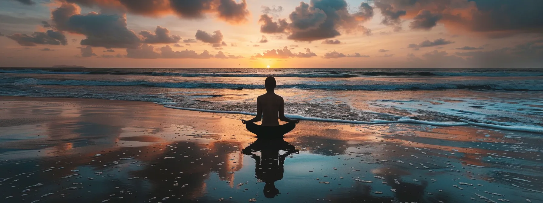 a serene individual sits cross-legged on a tranquil beach at sunrise, embodying mindfulness as gentle waves wash ashore, symbolizing calmness and emotional resilience in the face of challenges.