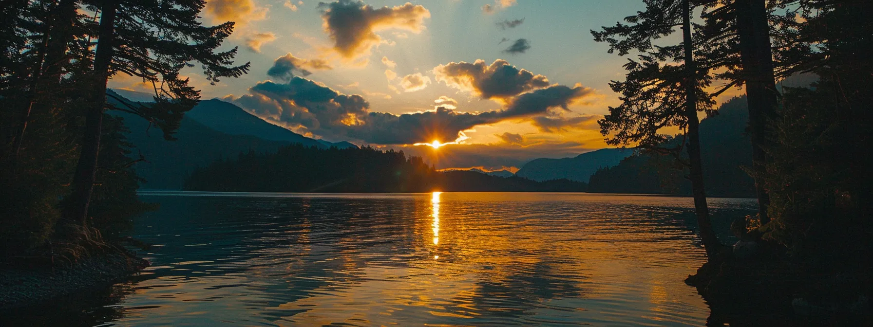 a vibrant sunset casts a golden glow over a tranquil lake, with silhouetted trees framing the water's edge, creating a serene and reflective atmosphere.