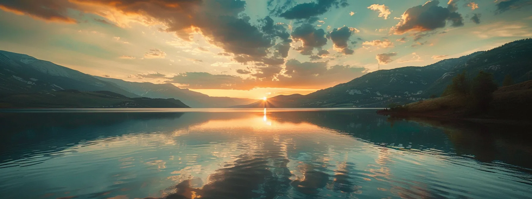 ein atemberaubender sonnenuntergang über einem stillen see, dessen spiegelglattes wasser die leuchtenden farben des himmels wider spiegelt und eine friedliche atmosphäre schafft.